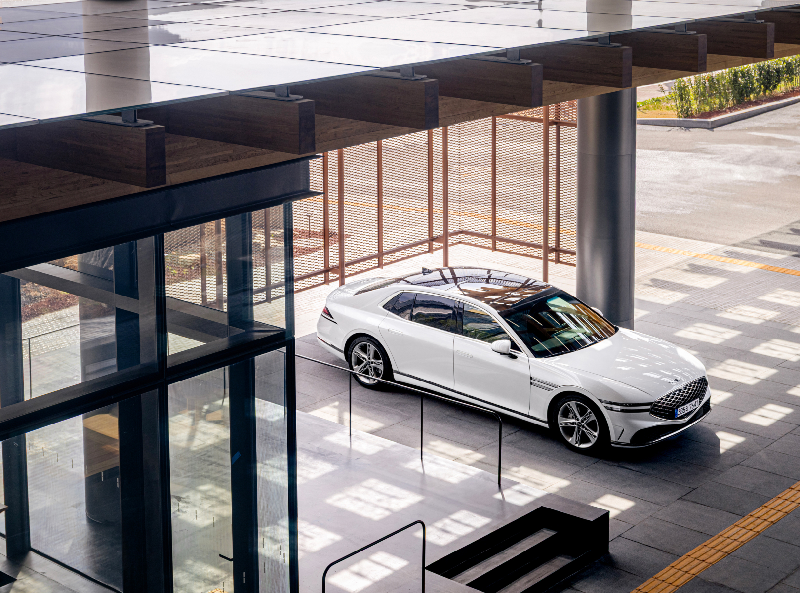The side of a Genesis G90 vehicle is visible inside the space.
