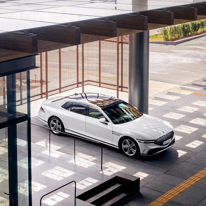 The side of a Genesis G90 vehicle is visible inside the space.